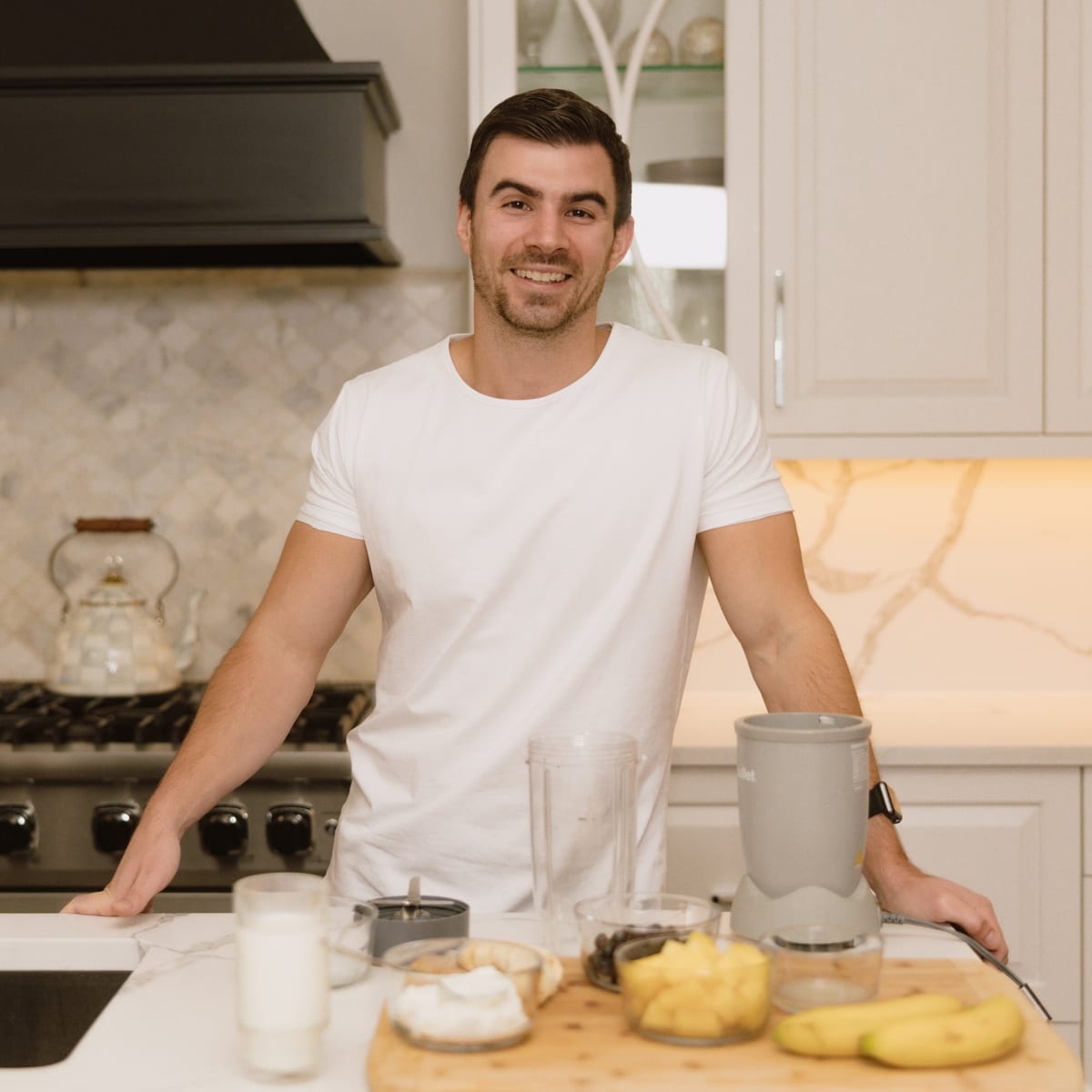 Nate Bladecki, registered dietitian, standing in a kitchen with fresh whole foods on the counter.